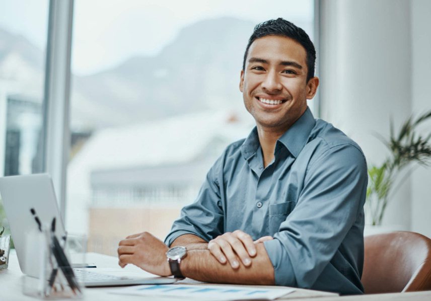 Man at desk with window smiling